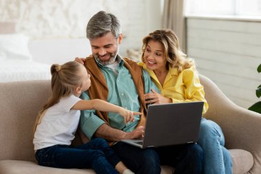 Mutlu Ebeveynler ve Kızları Evde Dizüstü bilgisayar kullanıyor