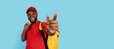 Güzel teklif. Kamerayı gösteren termal sırt çantası takan neşeli siyah teslimatçı.