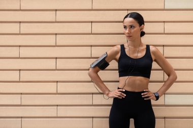 Spor üniformalı, spor kıyafetli, spor salonunda dinlenen, kendine güvenen, narin, genç bir Arap kadın.