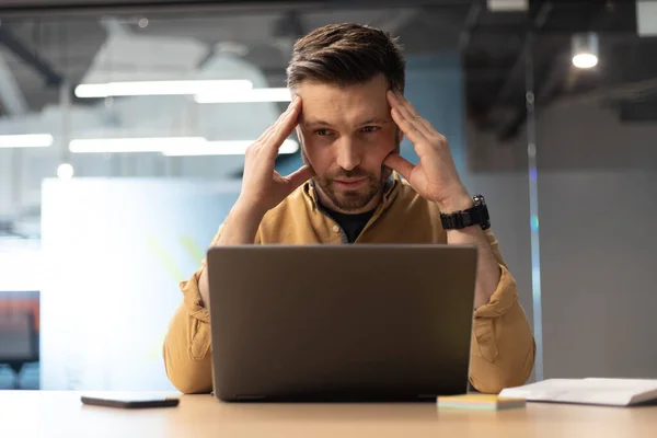 Geschäftsmann mit Laptop leidet unter Kopfschmerzen und hat Probleme im Büro — Stockfoto