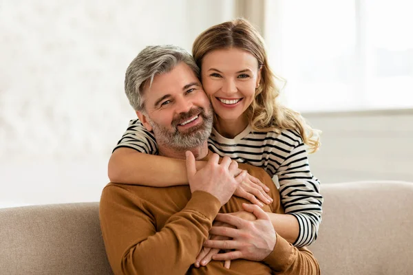 Любляча середнього віку пара приймає сидячи на дивані вдома — стокове фото