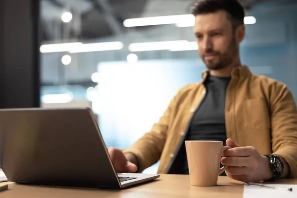 Επιχειρηματίας χρησιμοποιώντας Laptop πίνοντας καφέ εργασίας σε απευθείας σύνδεση στο γραφείο — Φωτογραφία Αρχείου