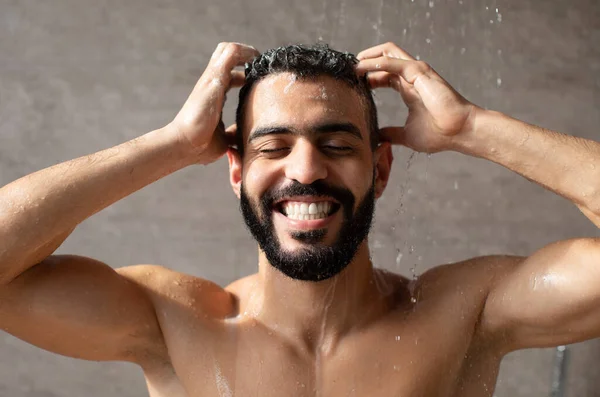 Feliz guapo joven árabe masculino modelo tomando ducha caliente — Foto de Stock