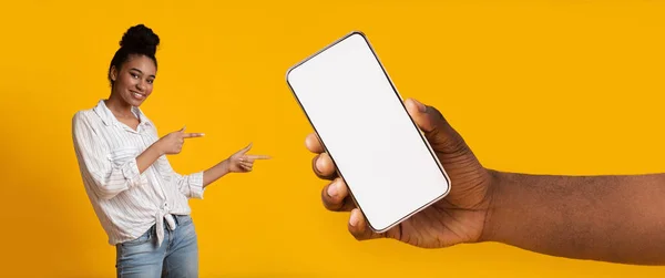 Black lady pointing at white empty smartphone screen, mockup