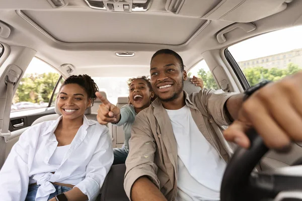 Emocionado familia negra conduciendo nuevo auto, hija señalando dedo —  Fotos de Stock