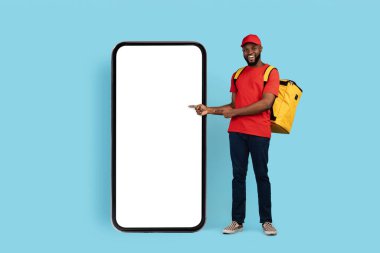 Sipariş ver. Mutlu Siyah Teslimatçı Adam Büyük Boş Akıllı Telefon Ekranını Gösteriyor