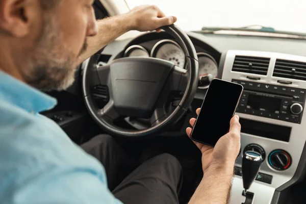 Autofahrer fährt mit Smartphone mit leerem Bildschirm Auto — Stockfoto