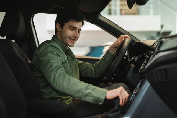 Boldog fiatal kaukázusi férfi teszt vezetés új autó vásárlás előtt a modern autó kereskedés, másolás hely — Stock Fotó