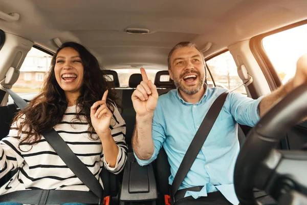 Ενθουσιασμένο ζευγάρι απολαμβάνει μουσική οδήγηση πολυτελές αυτοκίνητο — Φωτογραφία Αρχείου