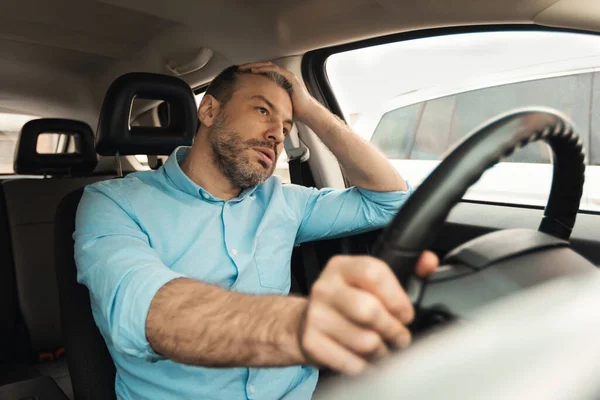 Verveelde man rijdt nieuwe auto in de stad — Stockfoto