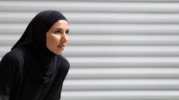 Lelah serius wanita muda arab mengenakan hijab beristirahat dari latihan kardio pada latar belakang dinding abu-abu, menutup — Stok Foto