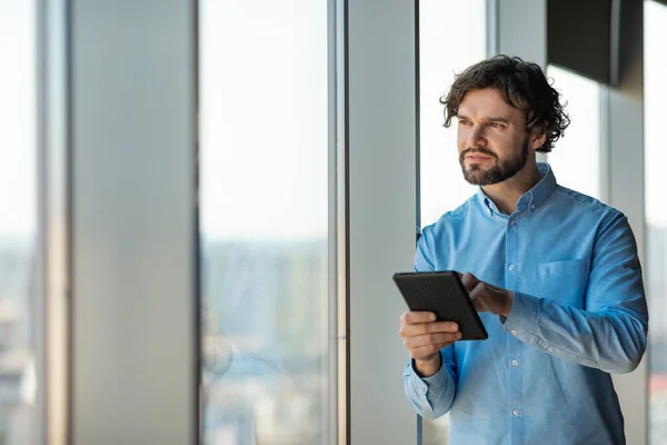 Portrait of man using digital tablet at office