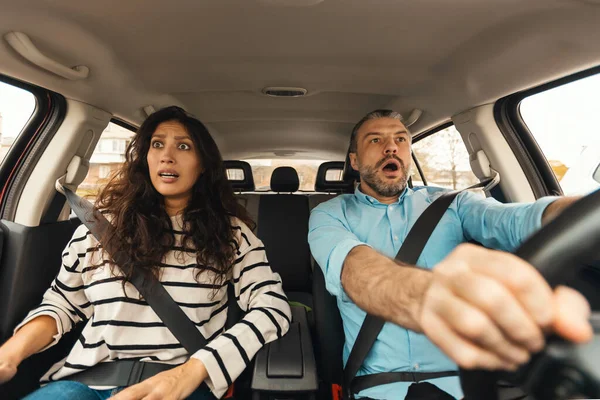 Casal assustado carro de condução, retrato frontal, vista para-brisa — Fotografia de Stock