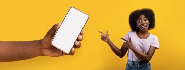 Siyah kadın beyaz, boş, akıllı telefon ekranını işaret ediyor.