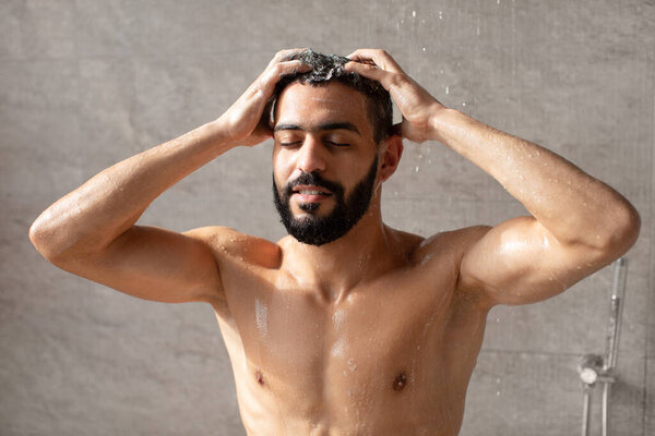 Handsome young Arabic male model taking hot shower