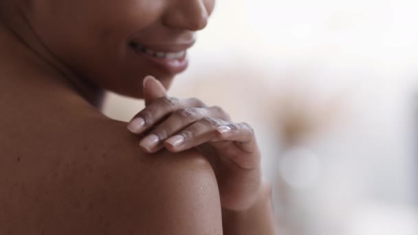 Letnia ochrona skóry. Nierozpoznawalna Afroamerykanka nakładająca krem na ramię i uśmiechnięta, pusta przestrzeń — Wideo stockowe
