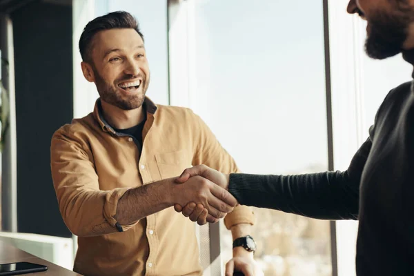 Business partnership. Two happy businessmen handshaking after successful deal at modern office — Stock Photo, Image