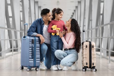 Havaalanında uçuş beklerken üç kişilik mutlu bir Arap ailesi.