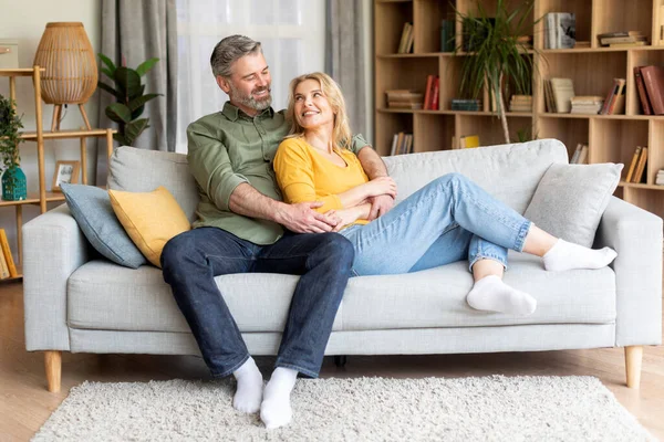 Романтична щаслива пара середнього віку, що розслабляється на дивані вдома — стокове фото