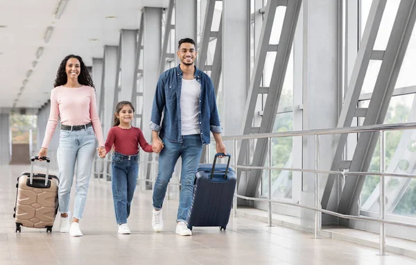 Äntligen semester. Spännande leende arabiska familjen håller händerna medan du går på flygplatsen — Stockfoto