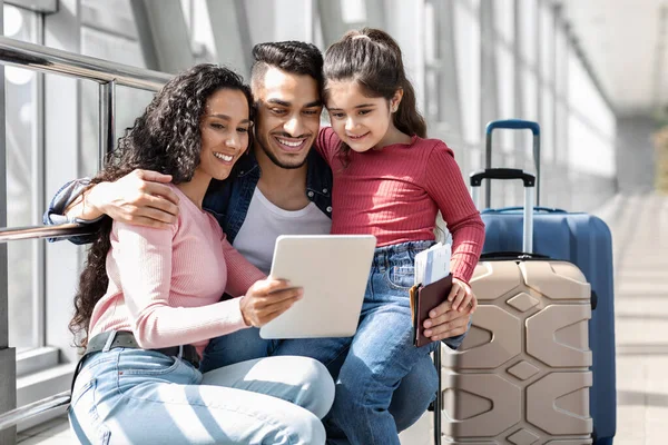 Familia árabe feliz de tres relajarse con tableta digital en el aeropuerto — Foto de Stock