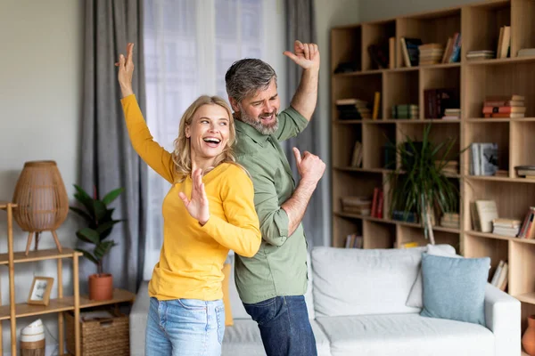 Positiv medelålders par dansar i vardagsrummet interiör, ha kul tillsammans — Stockfoto