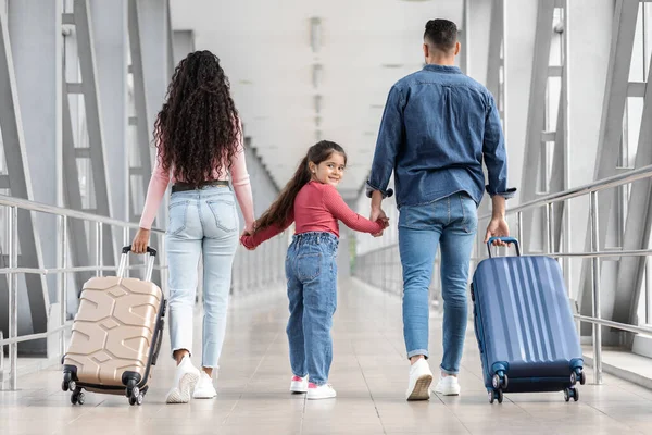 Bambina che va in vacanza con i genitori, cammina con le valigie in aeroporto — Foto Stock