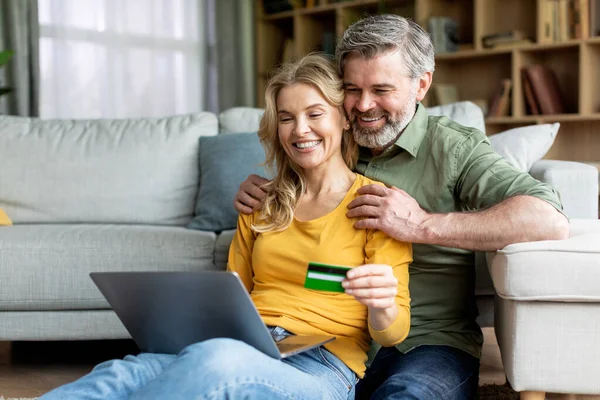 Εύκολες πληρωμές. Μεσήλικες σύζυγοι που ψωνίζουν online με φορητό υπολογιστή και πιστωτική κάρτα — Φωτογραφία Αρχείου