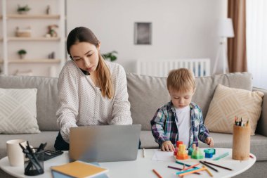 Genç bir anne çoklu görev yapıyor, cep telefonuyla konuşuyor, dizüstü bilgisayar kullanıyor ve oğluyla ilgileniyor, anne çocuğuna evde bakıcılık yaparken internette çalışıyor. Uzak iş fırsatları