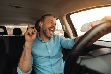 En sevdiği şarkı. Kablosuz kulaklıklı heyecanlı bir adamın portresi lüks bir araba sürüyor, müzik eşliğinde dans ediyor ve şarkı söylüyor, hafta sonları dinleniyor yaz tatiline çıkıyor, ön cam manzarası var.