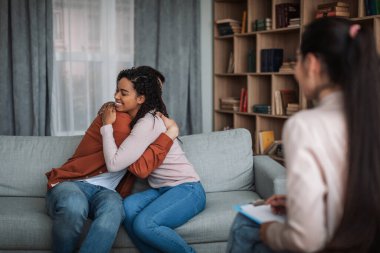 Genç ve mutlu Avrupalı koca ve Afrikalı Amerikalı eş klinikte psikiyatristle görüşürken sarılıyorlar. Tedavide uzlaşma, psikolojik problem çözme, aile terapisi ve destek