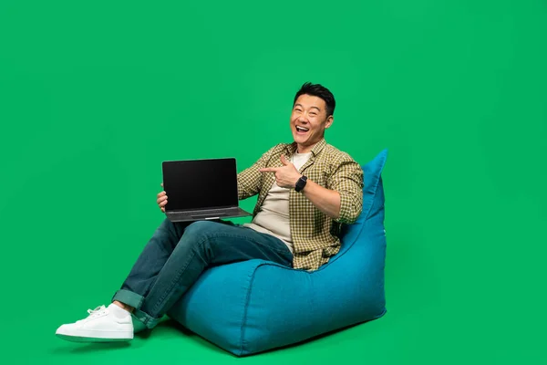 Fajna Strona Szczęśliwy Dojrzały Azjata Wskazujący Laptopa Pustym Ekranem Siedzący — Zdjęcie stockowe