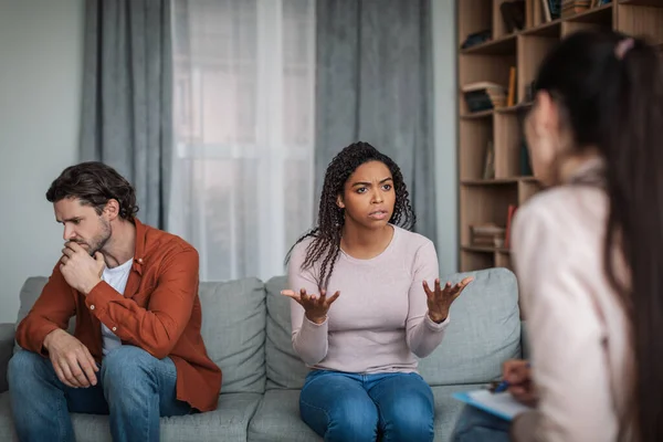 愤怒而不满的年轻黑人妻子与心理学家交谈 而忽视了诊所内部的欧洲裔丈夫 家庭咨询 解决心理问题 治疗和医疗支助 — 图库照片