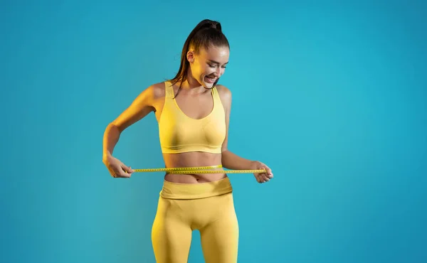 Sporty Woman Tape Measuring Waist Success Slimming Standing Blue Studio — 스톡 사진