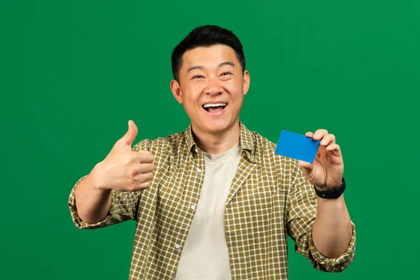 Щасливий Зрілий Азіатський Чоловік Тримає Кредитну Картку Показує Великий Палець — стокове фото