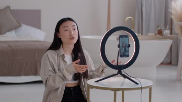 生活方式博客 年轻的亚洲女性影响者在智能手机上为社交媒体录制视频 给订户讲故事 在家里靠着圆形灯坐着 慢动作 — 图库视频影像