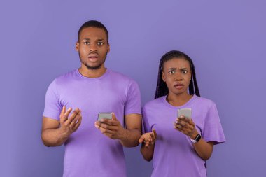 Üzücü ya da rahatsız edici içerik. Kafası karışmış binlerce yıllık Afrikalı Amerikalı çiftin portresi cep telefonlarını tutuyorlar, omuzlarını silkip kameraya bakıyorlar, mor menekşe duvarda tek başlarına duruyorlar.