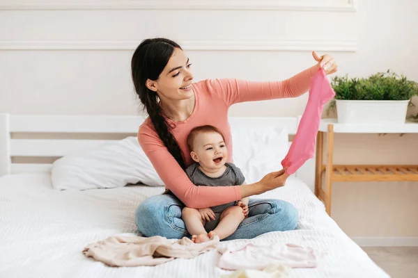 Joyeux Jeune Mère Avec Son Enfant Vérifier Nouveaux Vêtements Assis — Photo