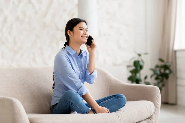 Vrolijke Aantrekkelijke Jonge Chinese Vrouw Zit Bank Praten Mobiele Telefoon — Stockfoto
