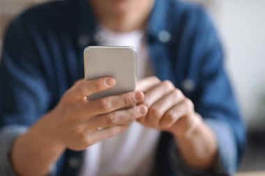 Modern Teknolojiler. Tanımlanamayan Genç Adam 'ın Tanımlanamayan Fotoğrafı, Sıradan Giysiler İçinde Erkek Cep Telefonu Tutuşu, Mesajlaşma veya Alışveriş İnternetinde, Seçici Odaklı Kesilmiş Görüntü