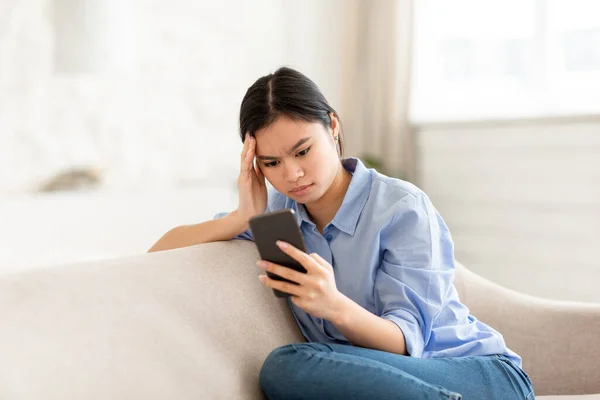 Geconcentreerde Duizendjarige Aziatische Vrouw Casual Outfit Zittend Comfortabele Bank Thuis — Stockfoto