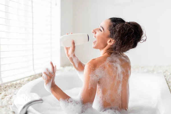 Gelukkige Jonge Vrouw Neemt Bubbelbad Met Behulp Van Shampoo Fles — Stockfoto