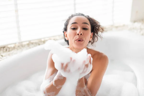 きれいな千年紀の女性泡風呂で吹いて 自宅でお湯で遊んでいます 魅力的な若い女性は彼女の体の世話をします 楽しみを持っています ホテルでスパの美しさの手順を楽しみます — ストック写真