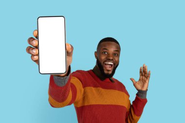 Reklam için yer. Elinde Büyük Boş Akıllı Telefon, Yeni Uygulama ya da Web Sitesi 'ne Reklam Veren Neşeli Afrikalı Amerikalı Adam Mavi Arkaplanda İzole Edilmiş, Mockup