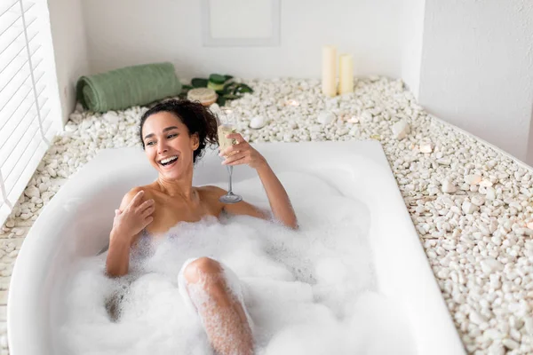 목욕을 샴페인 마시며 집에서 휴가를 보내는 기분좋은 천년기 호텔의 욕조에서 — 스톡 사진