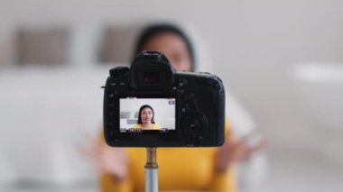 Modern meslek ve yaşam tarzı. Sosyal medya için video kaydeden, seçici odaklı genç, mutlu Afrikalı Amerikalı kadın ve kadın kameranın yakın çekim görüntüsü.
