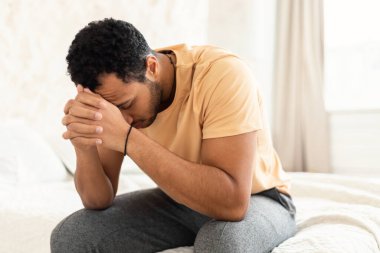 Erkek Depresyonu. Yüzü örten mutsuz Orta Doğulu adam evde yatak odasında otururken stres ve sorunlar yaşıyor. Depresif düşüncelerden muzdarip tanınmaz bir adam. Akıl Sağlığı Konsepti