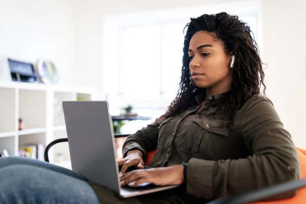 Donna Nera Focalizzata Cuffie Senza Fili Utilizzando Digitando Sulla Tastiera — Foto Stock