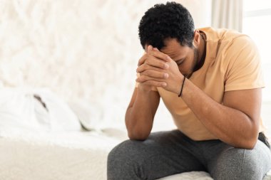 Depresyon. Yatak odasında yatağında oturan, stres ve yalnızlık yüzünden acı çeken, tanınmamış Arap bir adam. Hüsran, Olumsuz Duygular Konsepti