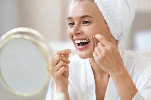 Atractiva Señora Mediana Edad Mirando Espejo Usando Hilo Dental Limpiando —  Fotos de Stock